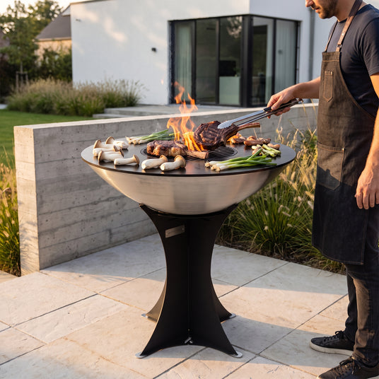 Tomahawk steaks searing on the Arteflame 40-inch Platinum Series stainless steel grill with tall Euro base on a contemporary terrace