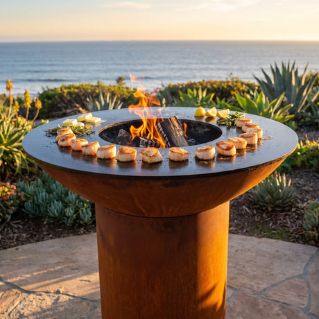 Seared sea scallops with a golden crust on an Arteflame wood-fired flat-top grill with a round Corten steel base