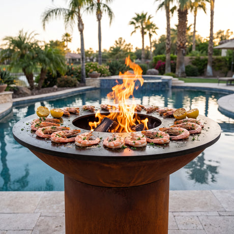 Garlic butter shrimp grilling on an Arteflame wood-fired flat-top grill with a round Corten steel base