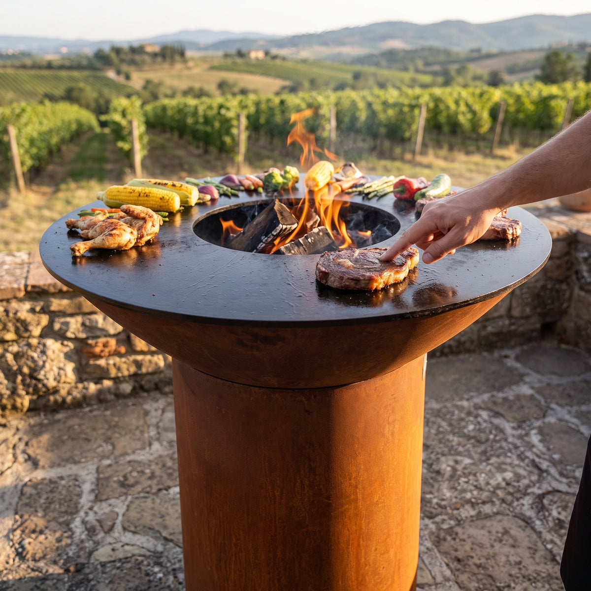 Testing steak doneness with the touch test on an Arteflame wood-fired flat-top grill with a round Corten steel base