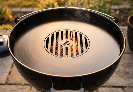 Arteflame Two-Piece Flat-Top Kit installed in a charcoal kettle grill, with lit charcoal glowing through the center grill grate